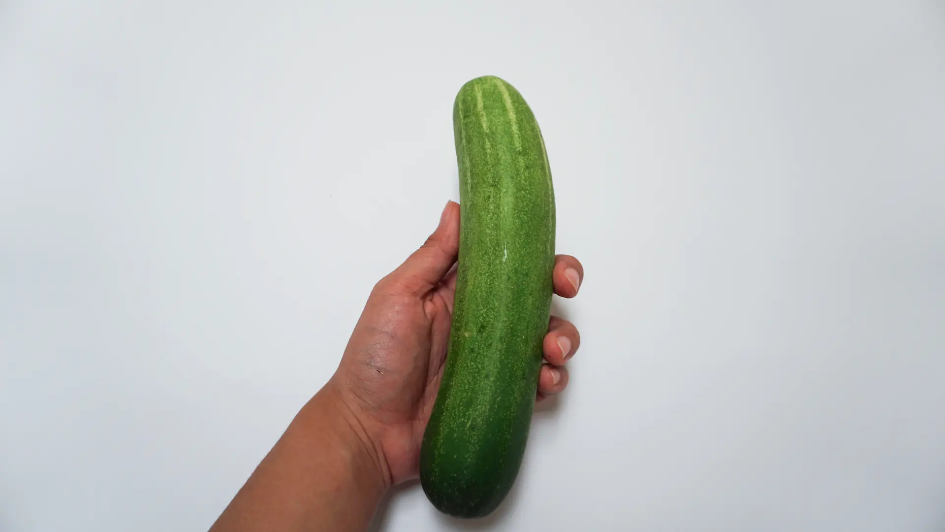 Frauenhand mit Gurke