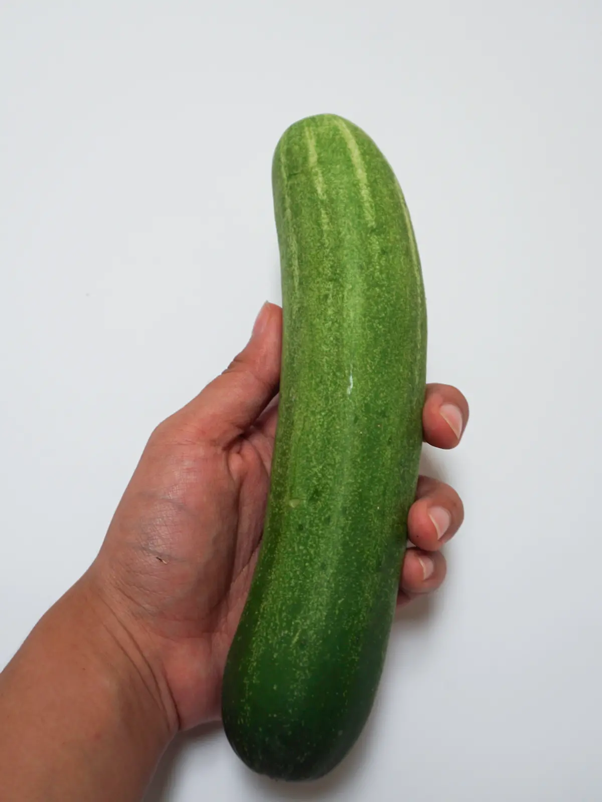 Frauenhand mit Gurke