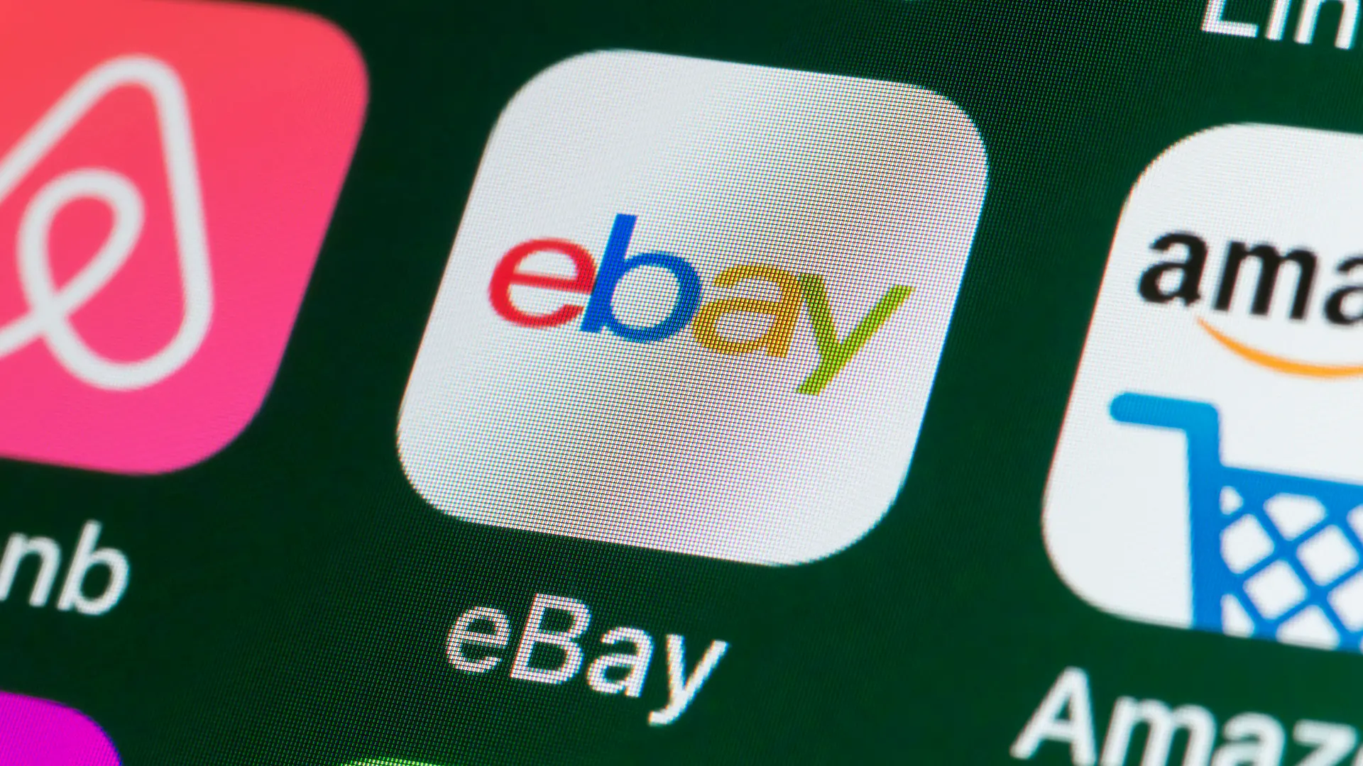 London, UK - July 31, 2018: The buttons of the online shopping app ebay, surrounded by Airbnb, Amazon, News and other apps on the screen of an iPhone.