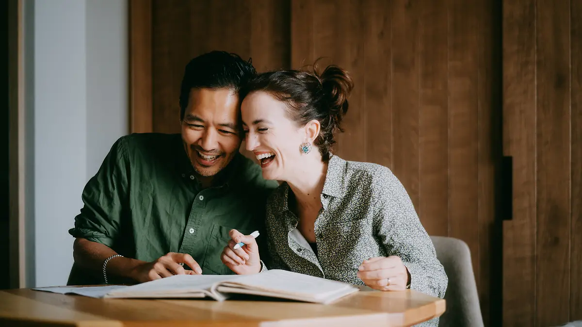 Ein glückliches Paar sitzt zusammen am Schreibtisch.