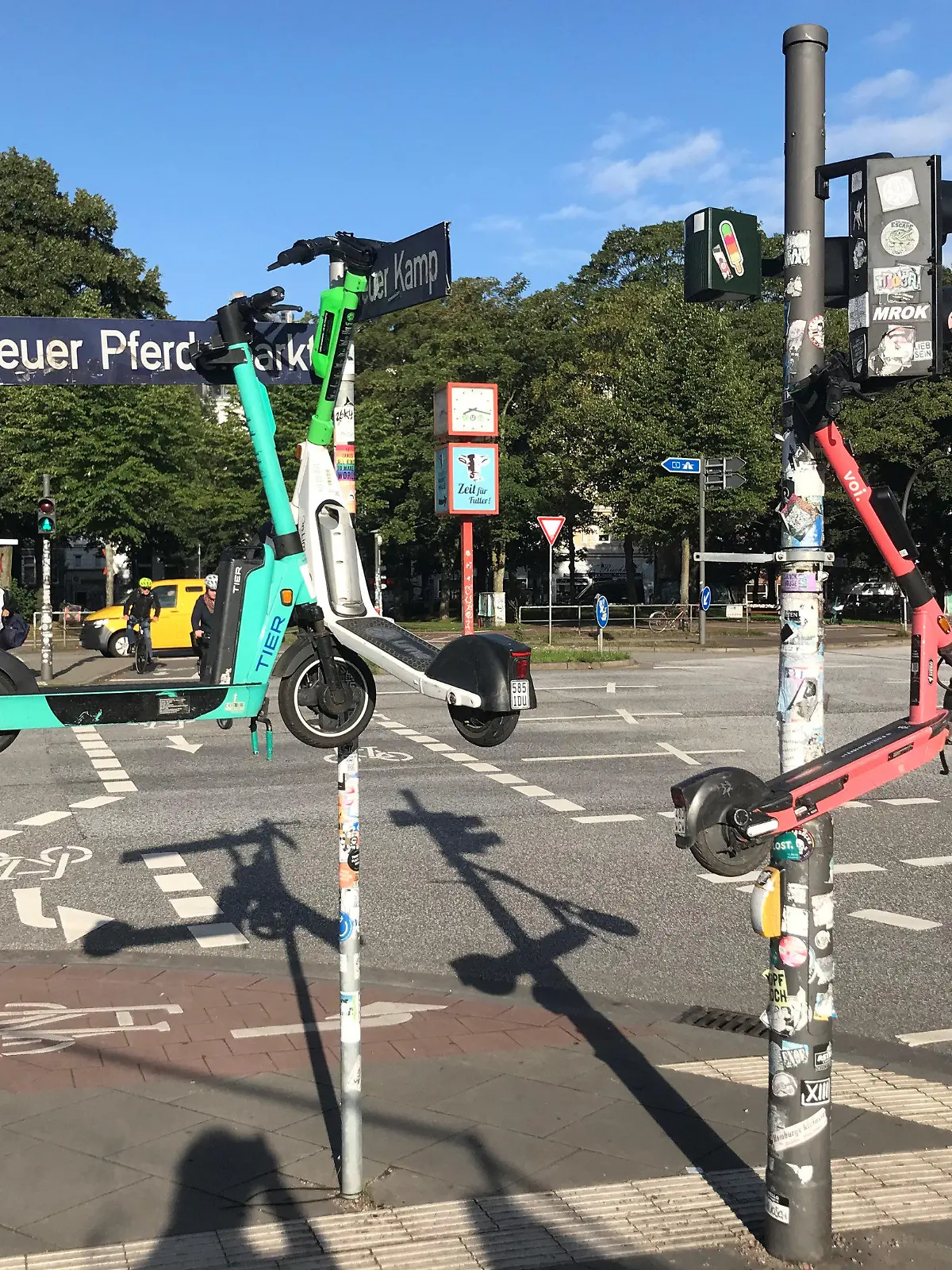 10.08.2023, Hamburg: Drei E-Scooter hängen an Masten im Stadtteil St. Pauli. Foto: Stefan Flomm/dpa +++ dpa-Bildfunk +++