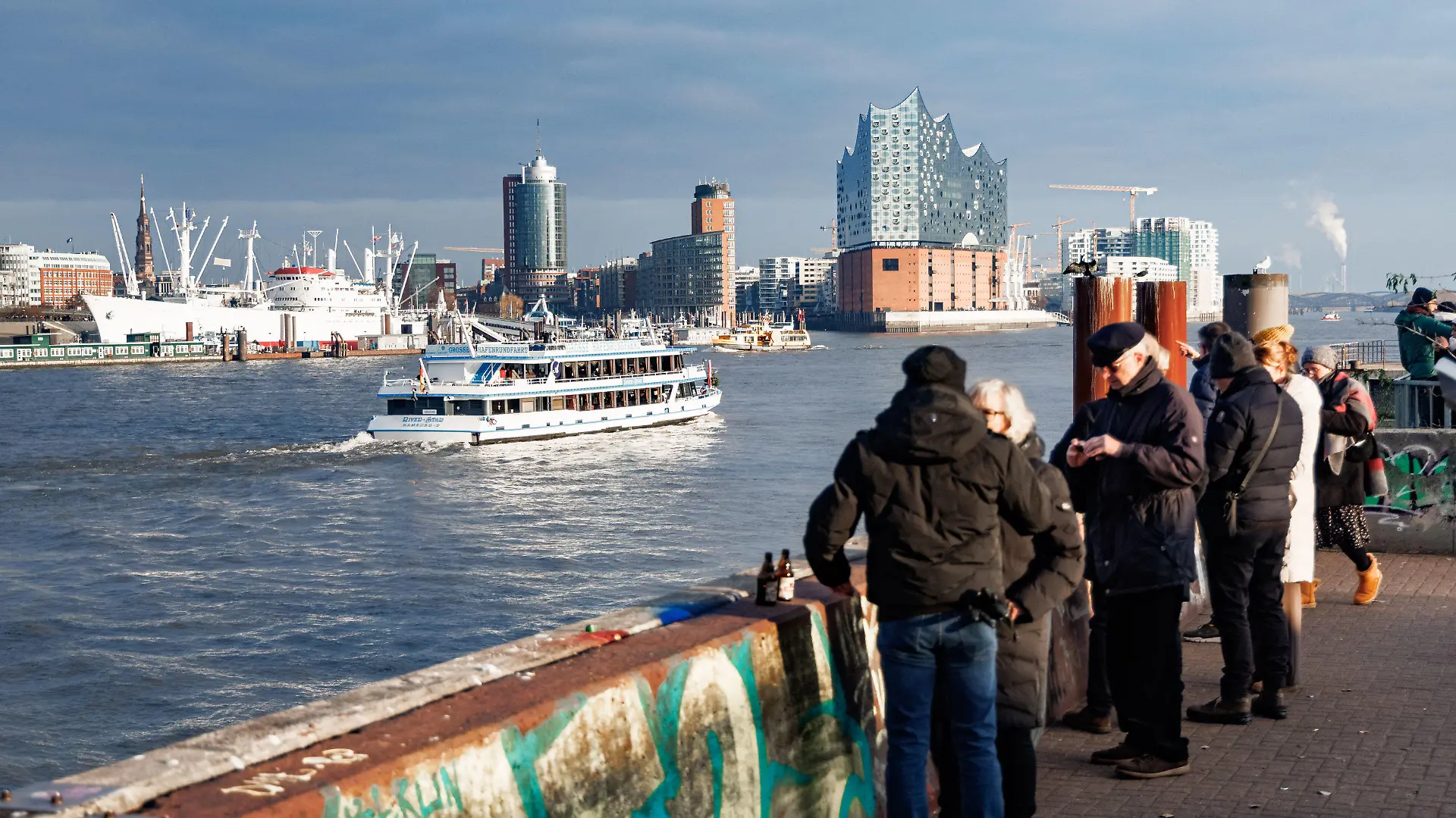 11.12.2022, Hamburg: Bei Null Grad Lufttemperatur und Sonnenschein betrachten Besucher vom Bornsteinplatz aus das Panorama der Hansestadt. Die Wolken über der Stadt können durchaus auch noch Schnee bringen. Foto: Markus Scholz/dpa +++ dpa-Bildfunk +++