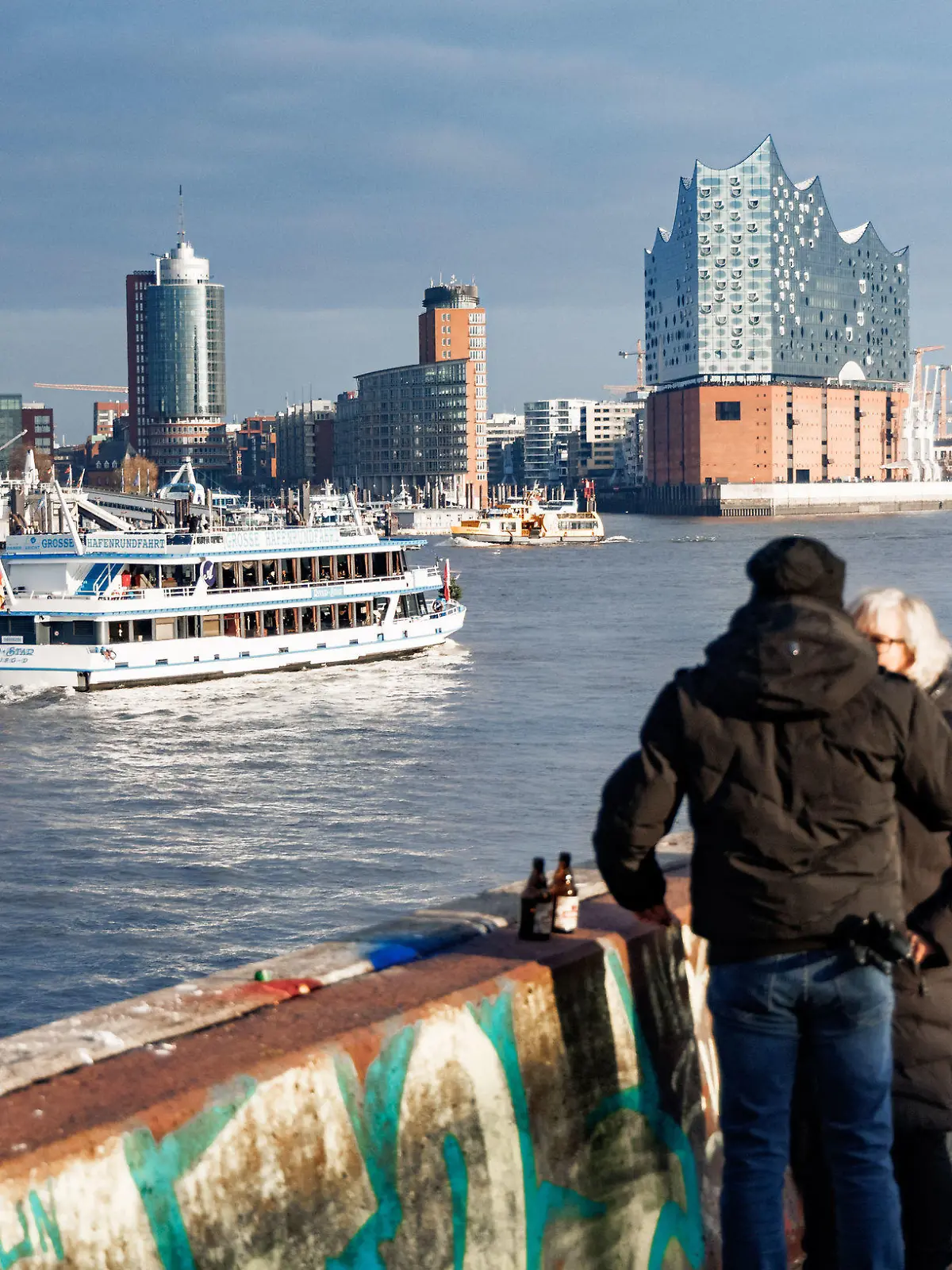 11.12.2022, Hamburg: Bei Null Grad Lufttemperatur und Sonnenschein betrachten Besucher vom Bornsteinplatz aus das Panorama der Hansestadt. Die Wolken über der Stadt können durchaus auch noch Schnee bringen. Foto: Markus Scholz/dpa +++ dpa-Bildfunk +++