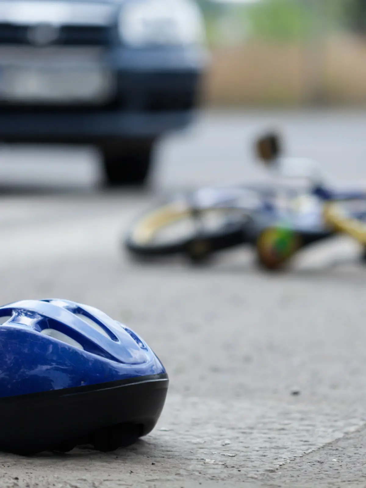 Ein Kinderrad und ein Fahrradhelm liegen auf einer Straße 