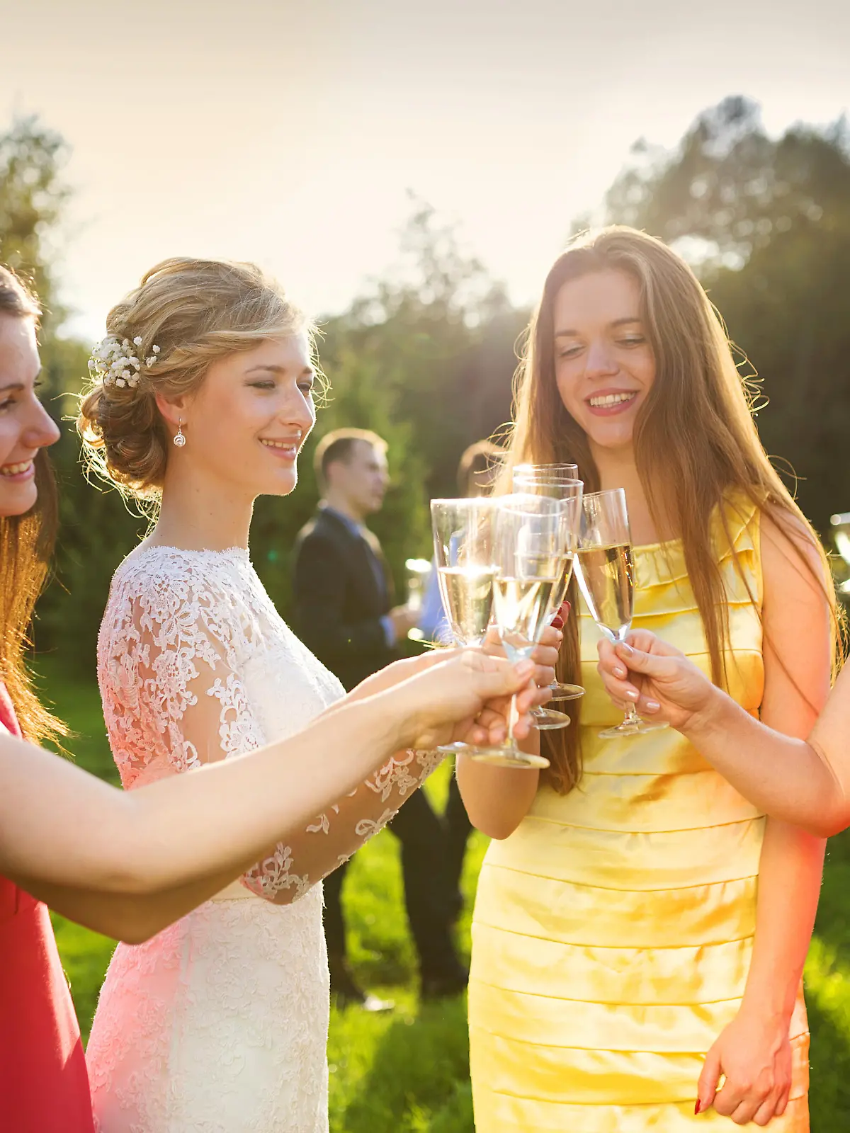 Bride with four happy bridesmaids toasting at the wedding reception outside