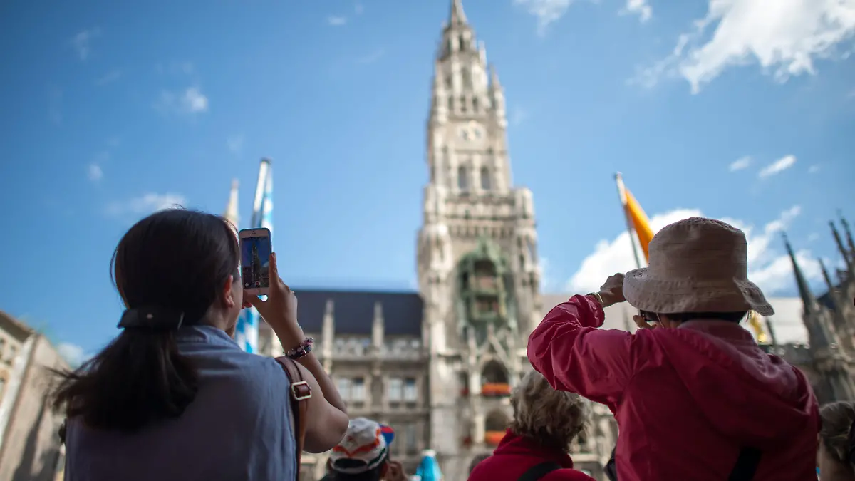 ARCHIV - Asiatische Touristinnen fotografieren am 27.07.2015 auf dem Marienplatz in München (Bayern) das Rathaus. Foto: Matthias Balk/dpa (zu dpa "Tourismus in München boomt - 3,2 Millionen Gäste im ersten Halbjahr" vom 13.08.2015) +++(c) dpa - Bildfunk+++