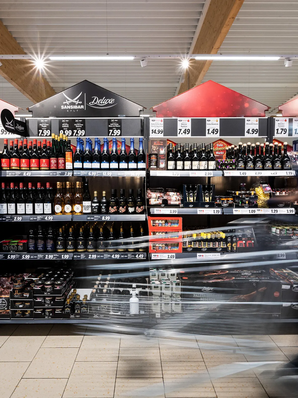 ARCHIV - 15.12.2021, Nordrhein-Westfalen, Kaarst: Ein Mann geht mit seinem Einkaufswagen in einer Lidl-Filiale an Regalen mit Sansibar und Deluxe-Produkten vorbei. In Nordrhein-Westfalen hat sich die Inflation Ende des Jahres abgeschwächt. Im Dezember seien die Verbraucherpreise im Jahresvergleich um 8,7 Prozent gestiegen, teilte das Statistische Landesamt am Dienstag mit. Im November hatte die Inflationsrate 10,4 Prozent betragen. (zu dpa «Inflation in Nordrhein-Westfalen schwächt sich deutlich ab») Foto: Federico Gambarini/dpa +++ dpa-Bildfunk +++