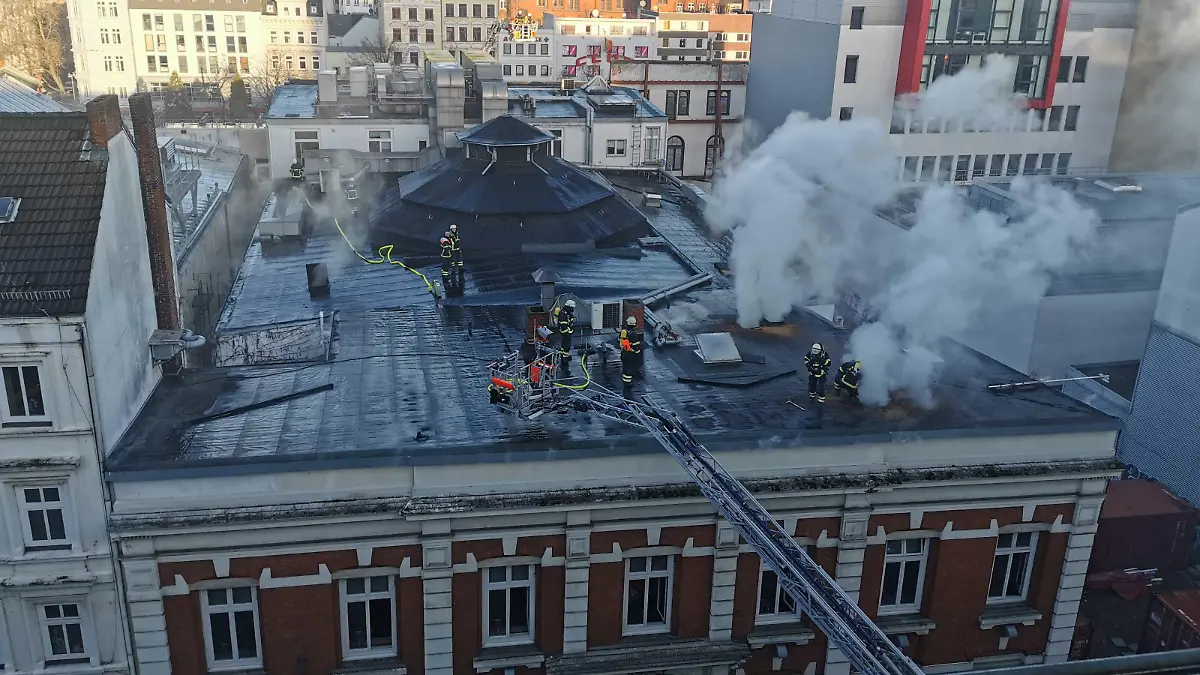 03.01.2023, Hamburg: Rauch steigt über dem Dach eines Theatergebäudes auf der Reeperbahn auf. Zwei Löschzüge seien im Einsatz, um den Brand zu bekämpfen, teilte die Feuerwehr auf Twitter mit. Betroffen sei ein Hintergebäude von Schmidts Tivoli.(zu dpa: «Brand an Theatergebäude auf St. Pauli - Feuerwehr im Einsatz») Foto: Steve Hutchings/TNN/dpa +++ dpa-Bildfunk +++