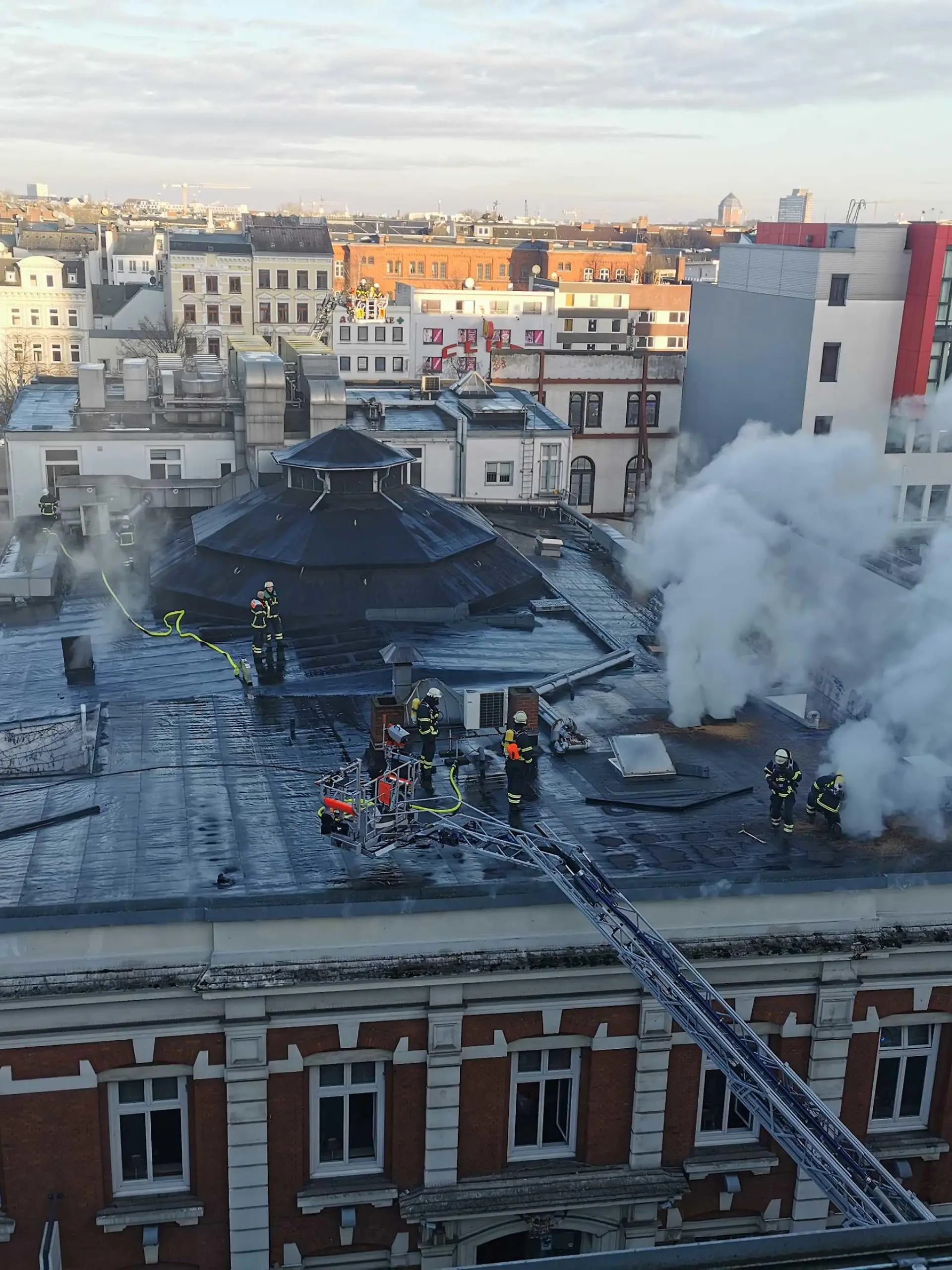 03.01.2023, Hamburg: Rauch steigt über dem Dach eines Theatergebäudes auf der Reeperbahn auf. Zwei Löschzüge seien im Einsatz, um den Brand zu bekämpfen, teilte die Feuerwehr auf Twitter mit. Betroffen sei ein Hintergebäude von Schmidts Tivoli.(zu dpa: «Brand an Theatergebäude auf St. Pauli - Feuerwehr im Einsatz») Foto: Steve Hutchings/TNN/dpa +++ dpa-Bildfunk +++