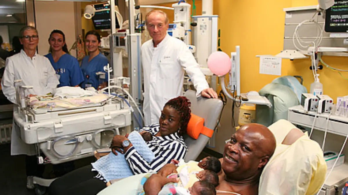 Vorne v. l.: Prof. Wolfgang Henrich, Direktor der Klinik für Geburtsmedizin, die Eltern mit vier Kindern. Hinten v. l.: Neonatologin Dr. Monika Berns, Gesundheits- und Kinderkrankenpflegerin Jessica Blauert und Jasmin Barthel, Studentin der Hebammenwissenschaften. Kind Nummer fünf liegt im Inkubator. 