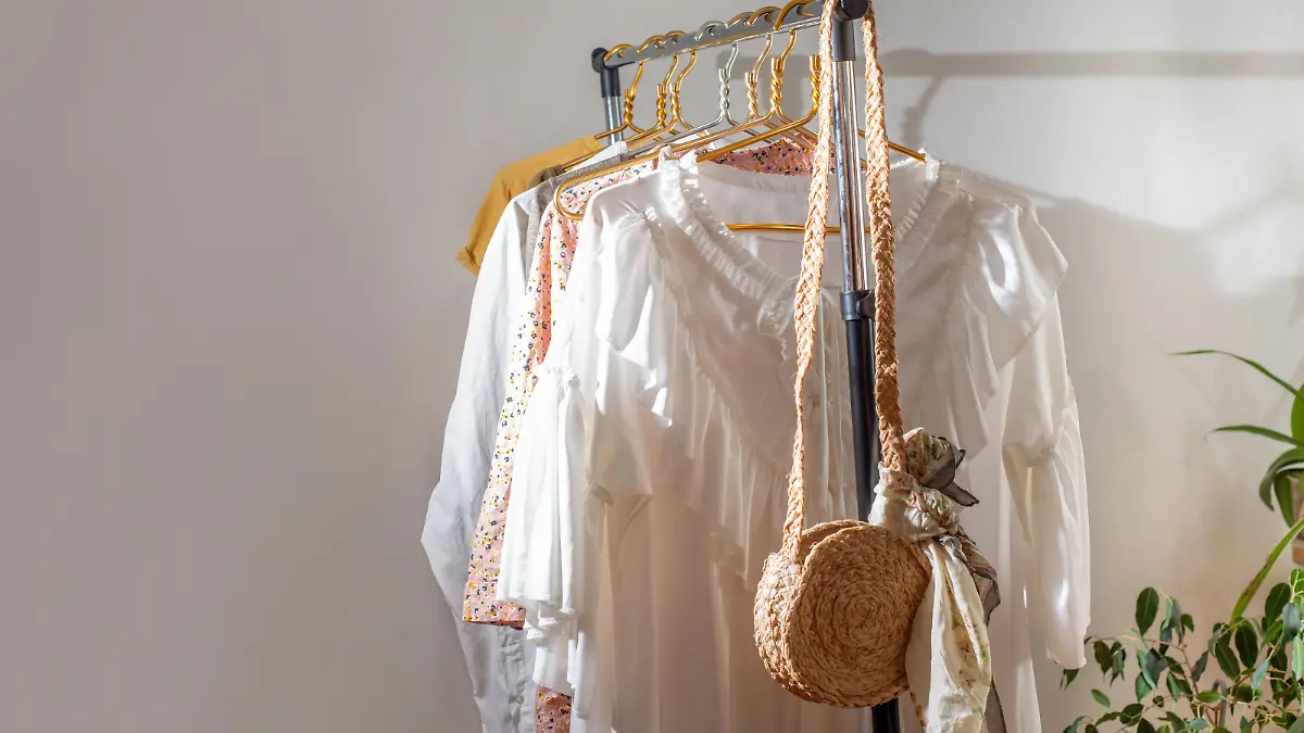 Second-hand clothes on the rail. The concept of sustainable economic life. Sale of clothes. Summer women's clothing on the swap. Clothing store