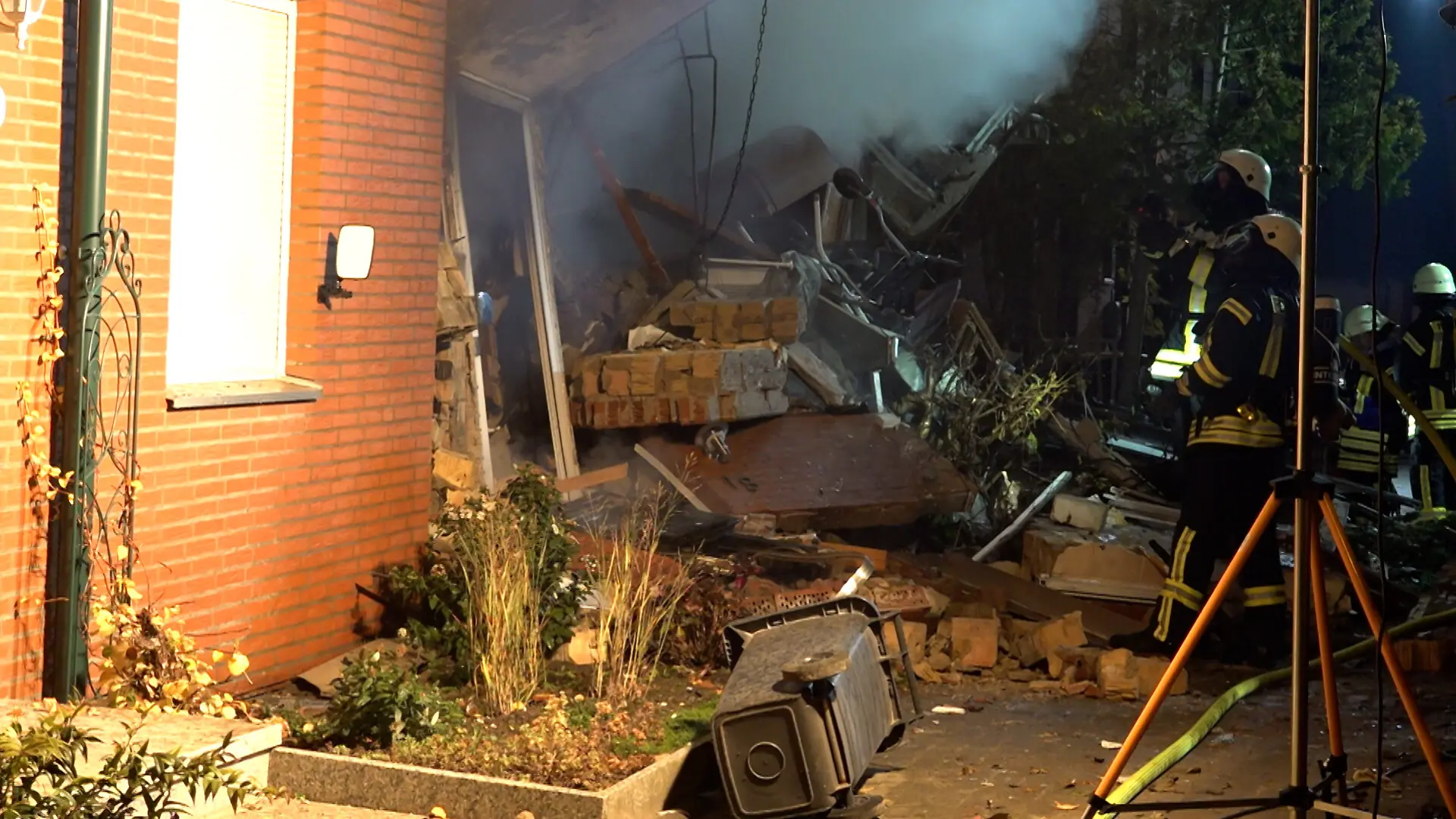 Einsatzkräfte der Feuerwehr sind im Einsatz an einem zerstörten Reihenhaus. Zuvor haben Anwohner eine Detonation gehört. 16 Menschen werden betreut, eine Person wird vermisst.