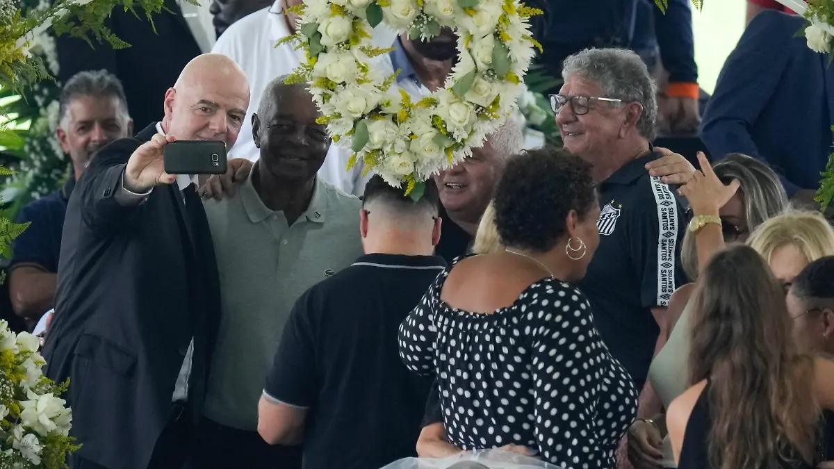 02.01.2023, Brasilien, Santos: FIFA-Präsident Gianni Infantino (l) macht ein Selfie mit Lima, einem ehemaligen Santos-Fußballspieler, und anderen während der Totenwache für den verstorbenen brasilianischen Fußballstar Pelé, dessen Leichnam im Vila Belmiro-Stadion aufgebahrt ist. Der Ausnahme-Fußballer Pele starb am 29.12.2022 im Alter von 82 Jahren in Sao Paulo. Foto: Andre Penner/AP/dpa +++ dpa-Bildfunk +++