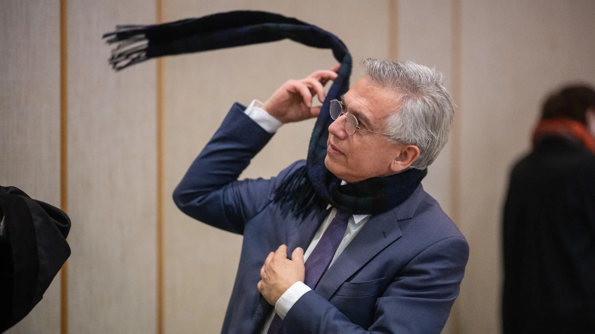 23.12.2022, Hessen, Frankfurt/Main: Der ehemalige Frankfurter Oberbürgermeister Peter Feldmann zieht sich nach der Urteilsverkündung im Prozess gegen ihn am Landgericht in dem Saal seinen Schal an. Der abgewählte Frankfurter Oberbürgermeister Feldmann (SPD) ist wegen Vorteilsannahme in zwei Fällen zu einer Geldstrafe verurteilt worden. Foto: Sebastian Gollnow/dpa-Pool +++ dpa-Bildfunk +++