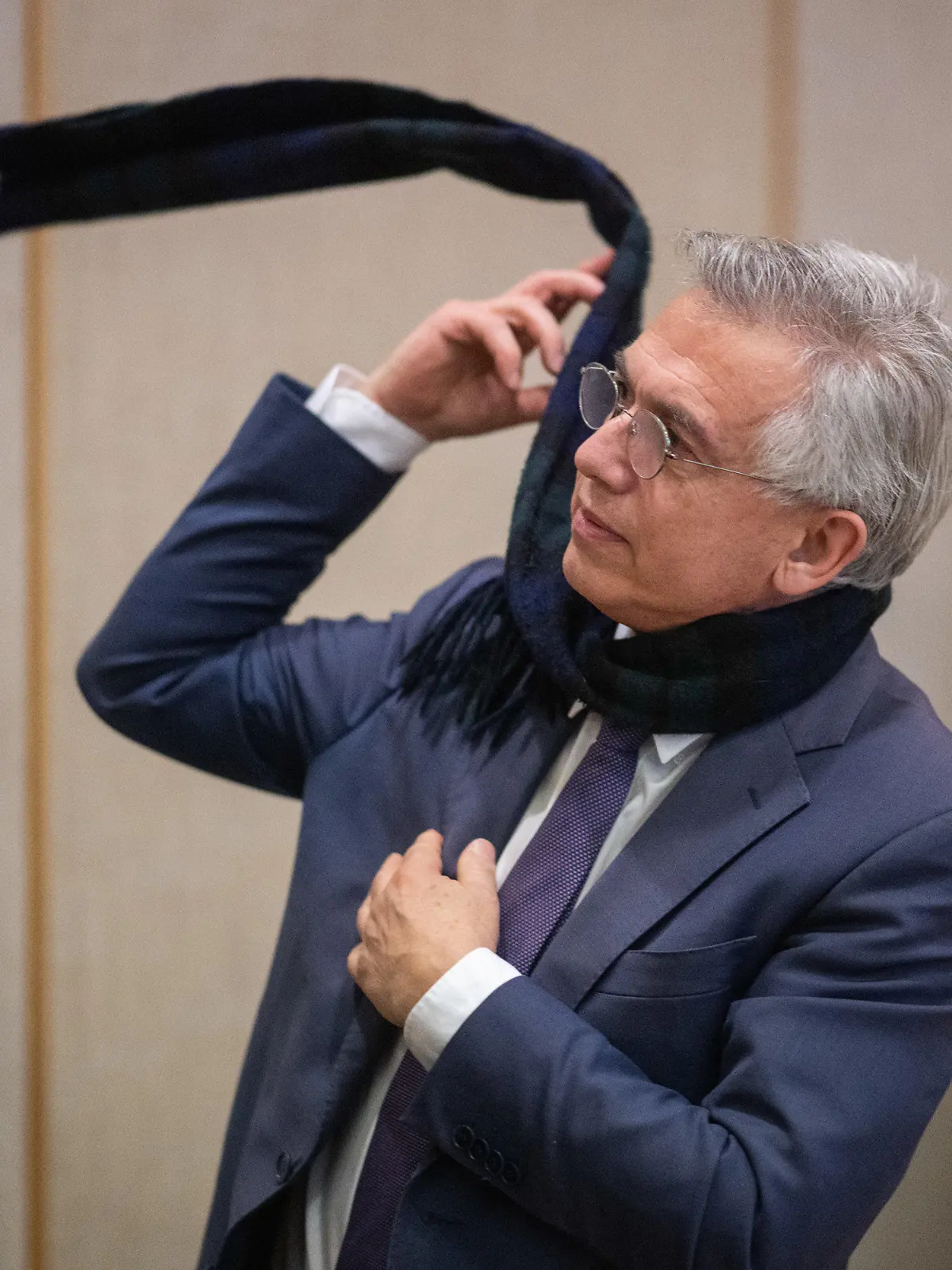 23.12.2022, Hessen, Frankfurt/Main: Der ehemalige Frankfurter Oberbürgermeister Peter Feldmann zieht sich nach der Urteilsverkündung im Prozess gegen ihn am Landgericht in dem Saal seinen Schal an. Der abgewählte Frankfurter Oberbürgermeister Feldmann (SPD) ist wegen Vorteilsannahme in zwei Fällen zu einer Geldstrafe verurteilt worden. Foto: Sebastian Gollnow/dpa-Pool +++ dpa-Bildfunk +++
