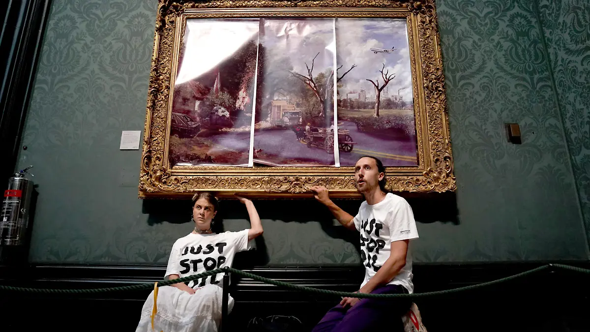 Eco-protesters court case. File photo dated 04/07/22 of protesters from Just Stop Oil climate protest group, who glued their hands to the frame of John Constable's The Hay Wain after first having covered the painting with their own picture at the National Gallery, London. Hannah Hunt and Eden Lazarus have appeared at Westminster Magistrates' Court charged with causing criminal damage to The Hay Wain painting and frame at the National Gallery. Issue date: Tuesday December 6, 2022. See PA story COURTS Oil. Photo credit should read: Kirsty O'Connor/PA Wire URN:70132281