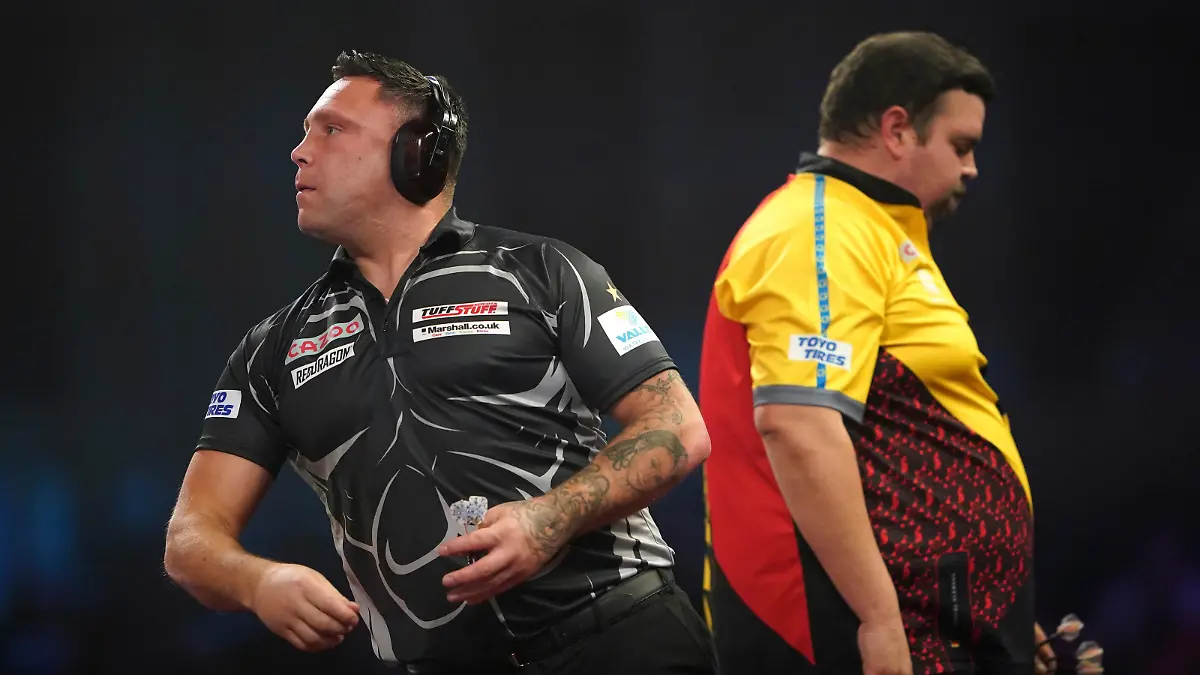 Wales' Gerwyn Price wears ear defenders as he plays against Germany's Gabriel Clemens, during day fourteen of the World Darts Championship at Alexandra Palace, in London, Sunday, Jan. 1, 2023. (Zac Goodwin/PA via AP)