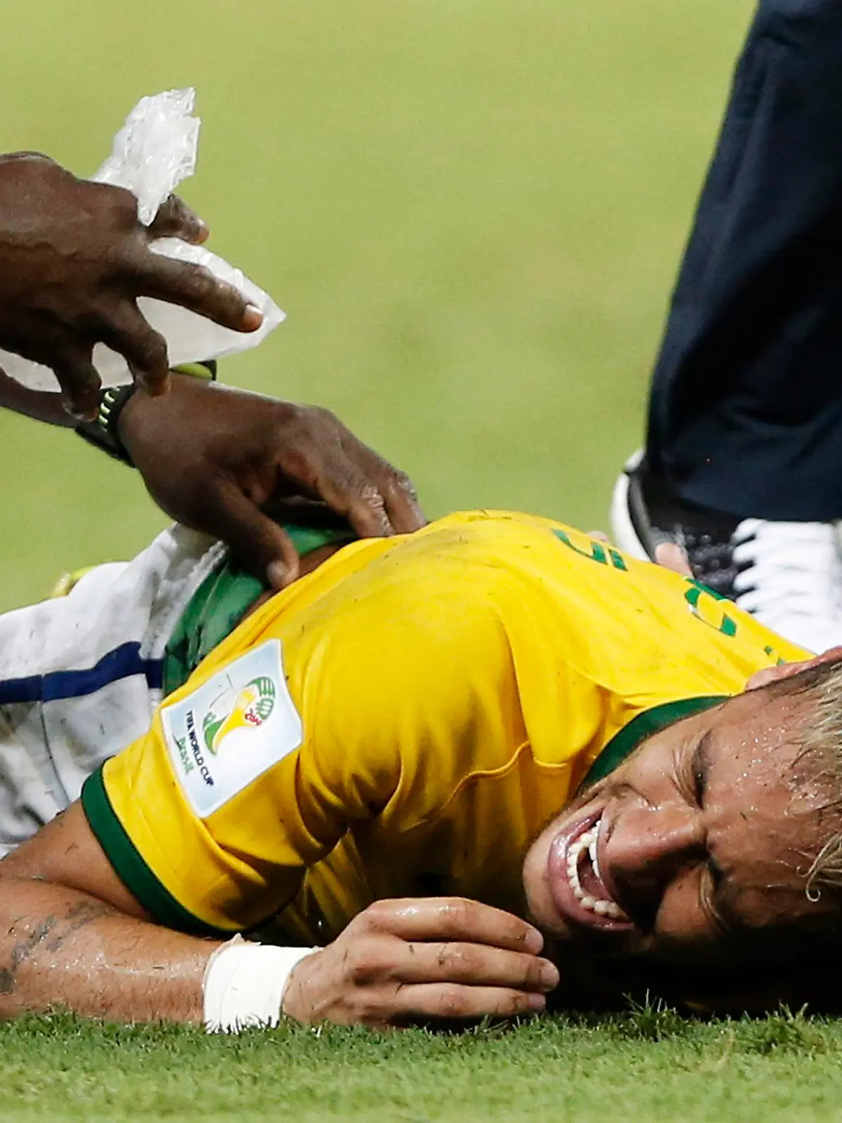epa04300304 Neymar of Brazil lies receives medial attention after picking up an injury during the FIFA World Cup 2014 quarter final match soccer between Brazil and Colombia at the Estadio Castelao in Fortaleza, Brazil, 04 July 2014. (RESTRICTIONS APPLY: Editorial Use Only, not used in association with any commercial entity - Images must not be used in any form of alert service or push service of any kind including via mobile alert services, downloads to mobile devices or MMS messaging - Images must appear as still images and must not emulate match action video footage - No alteration is made to, and no text or image is superimposed over, any published image which: (a) intentionally obscures or removes a sponsor identification image; or (b) adds or overlays the commercial identification of any third party which is not officially associated with the FIFA World Cup) EPA/TOLGA BOZOGLU EDITORIAL USE ONLY +++(c) dpa - Bildfunk+++