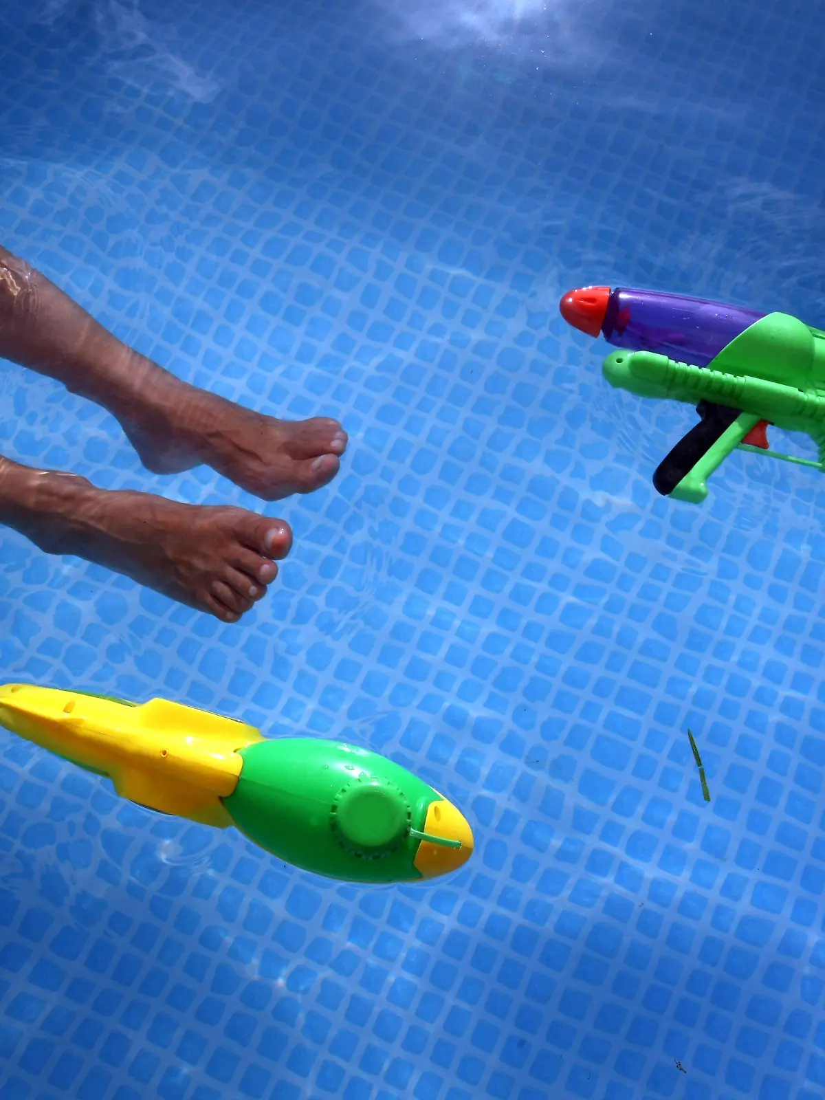 ILLUSTRATION - Eine Frau erfrischt sich am Sonntag (11.07.2010) in einem Gartenpool in Isny (Schwaben). Auf der Wasseroberfläche treiben zwei grellbunte Wasserpistolen. Weiterhin hochsommerlich ist das Wetter im Süden Deutschlands. Regionale Wärmegewitter sorgen jedoch vorübergehend für etwas Abkühlung. Foto: Karl-Josef Hildenbrand dpa/lsw/lby  +++(c) dpa - Bildfunk+++