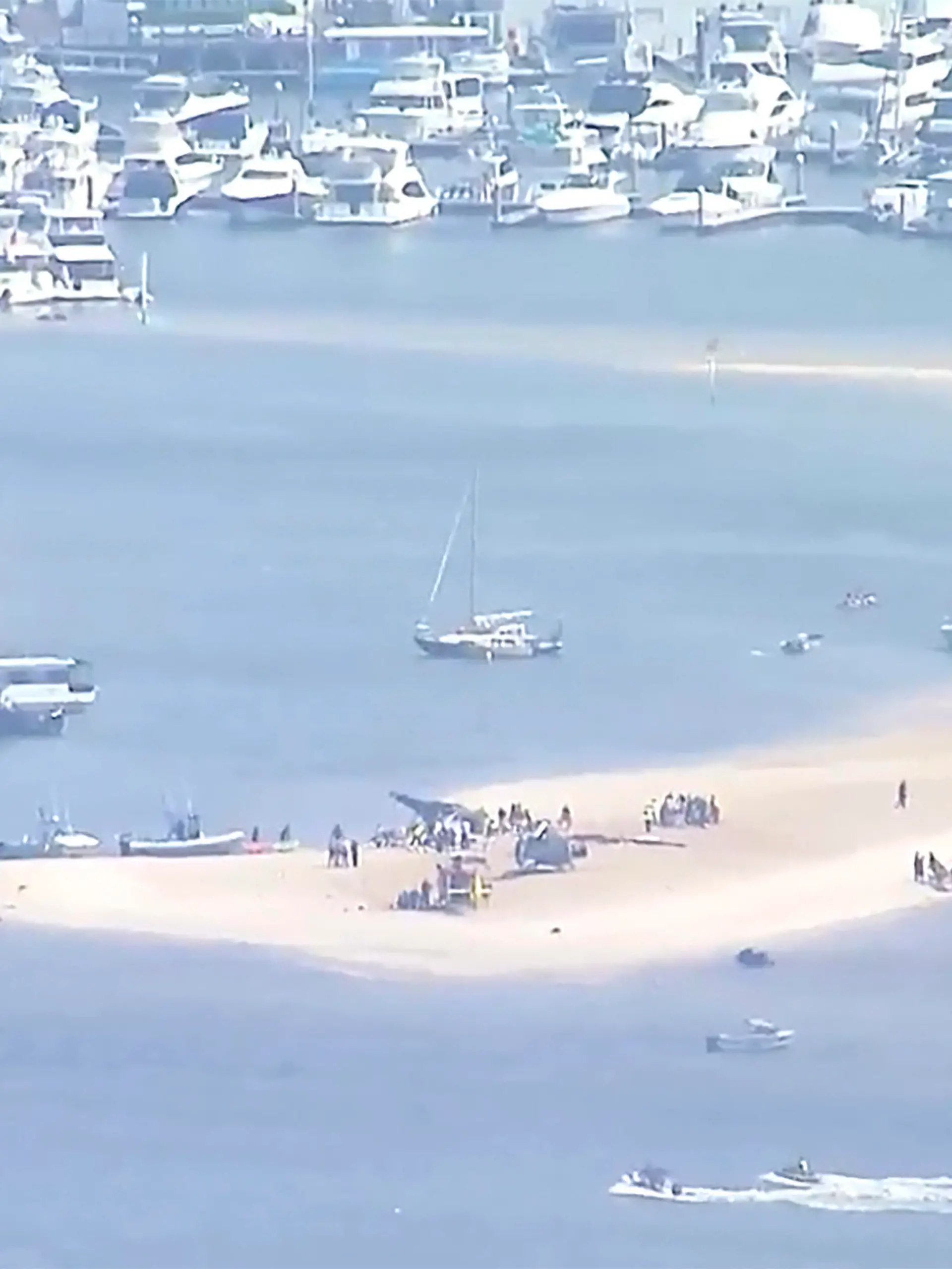 This image made from a video shows sand bank with crashed helicopter on Gold Coast, Australia Monday, Jan. 2, 2023. Two helicopters collided Monday afternoon over the Australian beach. (Australian Broadcasting Corp. via AP)