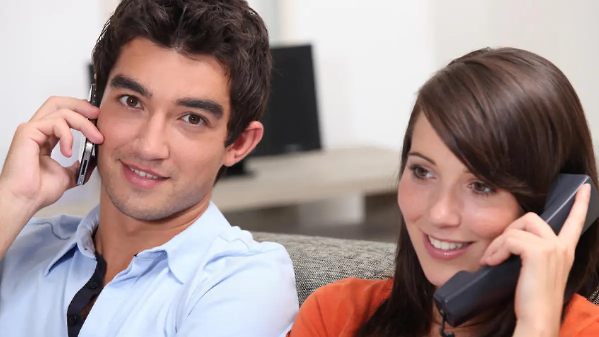 Young couple, both on the phone