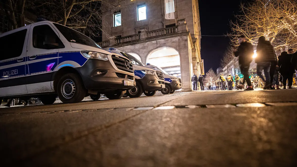 01.01.2023, Baden-Württemberg, Stuttgart: Einsatzwagen der Polizei stehen auf dem Schlossplatz bereit. Im Stuttgarter Stadtring gilt an Silvester ein Feuerwerksverbot - Die Stadt hat auf dem abgesperrten Schlossplatz eine Silvesterfeier organisiert. An den Eingängen zum Feiergelände gibt es Kontrollen, da laut Veranstalter Knallkörper sowie die Mitnahme von Glas aus Sicherheitsgründen nicht zugelassen sind - Die Polizei sorgt für Sicherheit. Foto: Christoph Schmidt/dpa +++ dpa-Bildfunk +++