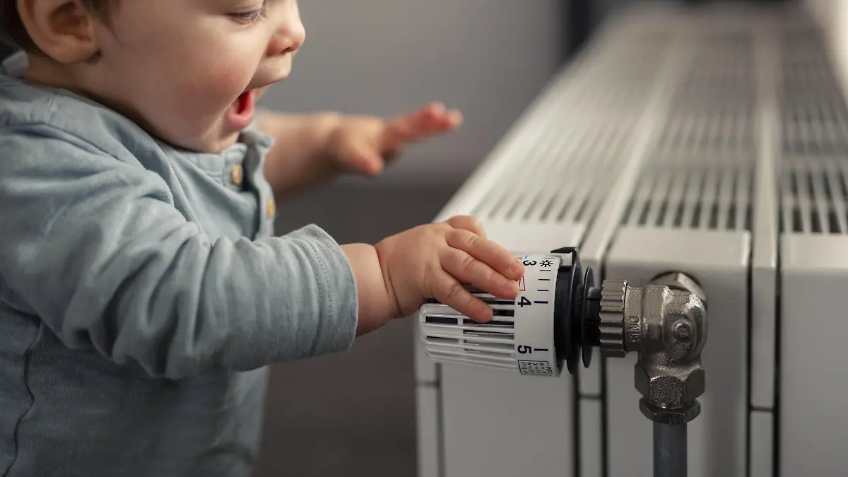 Excited baby boy playing with thermostat of heater model released Symbolfoto property released PUBLICATIONxINxGERxSUIxAUTxHUNxONLY SEBF00020  