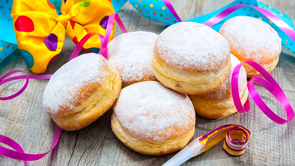 Krapfen or jelly doughnuts with jam and icing sugar