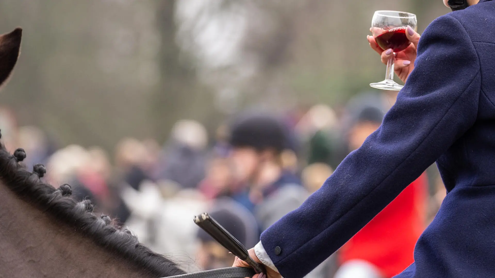 Сirencester, England - December 26, 2018: Woman Horse rider taking a tipple of Port at the annual Boxing day hunt, held in Cirencester Park, Gloucestershire, England