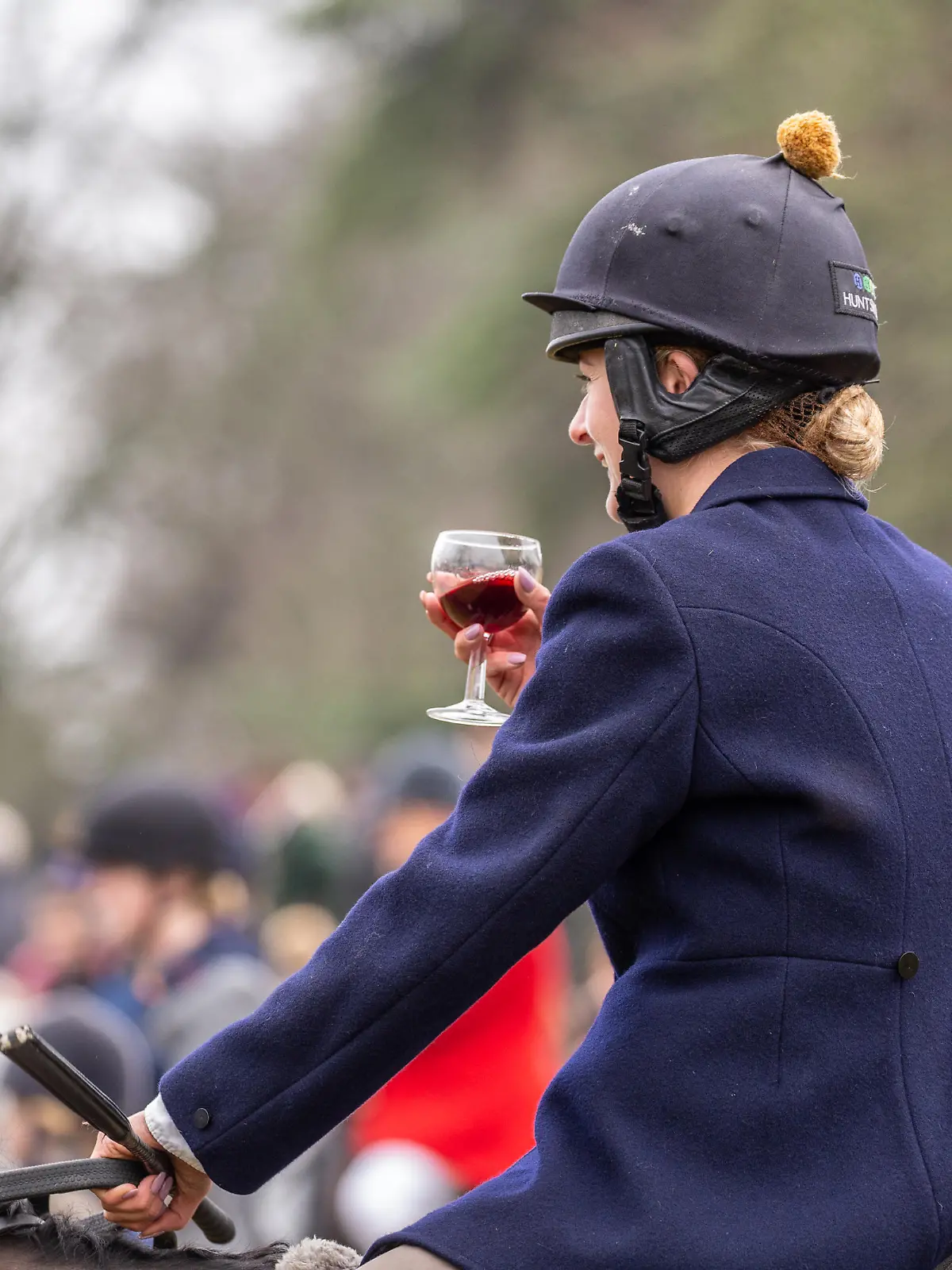 Сirencester, England - December 26, 2018: Woman Horse rider taking a tipple of Port at the annual Boxing day hunt, held in Cirencester Park, Gloucestershire, England