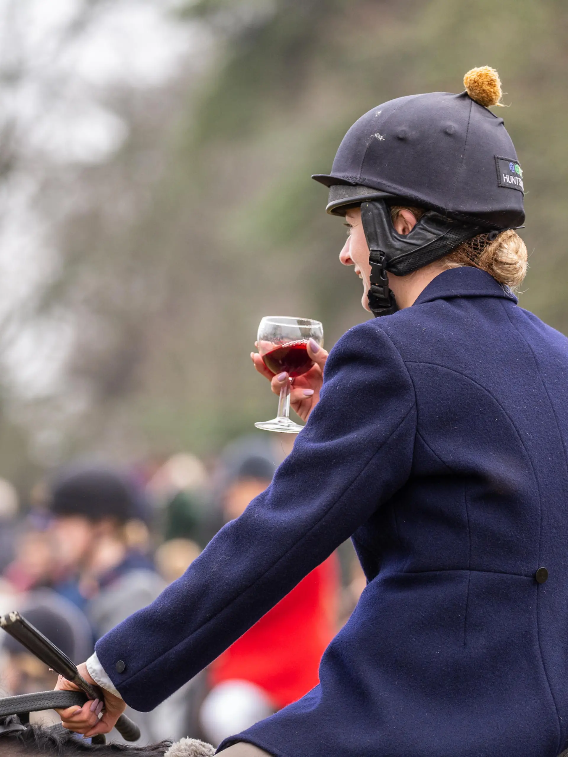 Сirencester, England - December 26, 2018: Woman Horse rider taking a tipple of Port at the annual Boxing day hunt, held in Cirencester Park, Gloucestershire, England