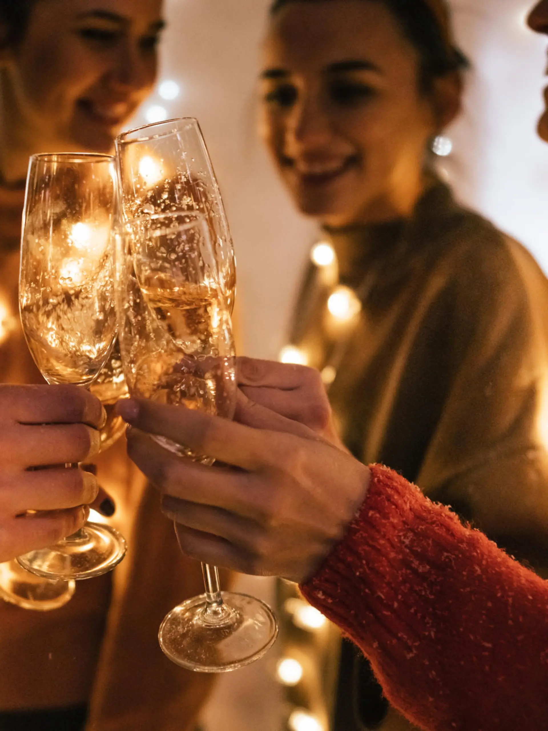 Photo of a small group of friends toasting with champagne and celebrating New Year's together; celebrating their youth and holidays.
