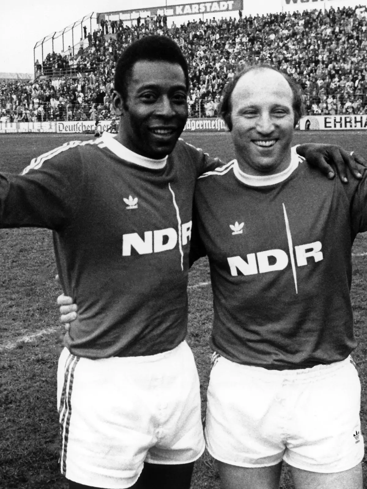 ARCHIV - 21.04.1975, Niedersachsen, Braunschweig: Der Ehrenspielführer der deutschen Fußball Nationalmannschaft, Uwe Seeler (r), und die brasilianische Fußball-Legende Pele winken bei einem Benefizspiel im Eintrachtstadion für die Fernsehlotterie "Ein Platz an der Sonne". Die brasilianische Fußball-Legende Pelé ist im Alter von 82 Jahren gestorben. Foto: Wolfgang Weihs/dpa +++ dpa-Bildfunk +++