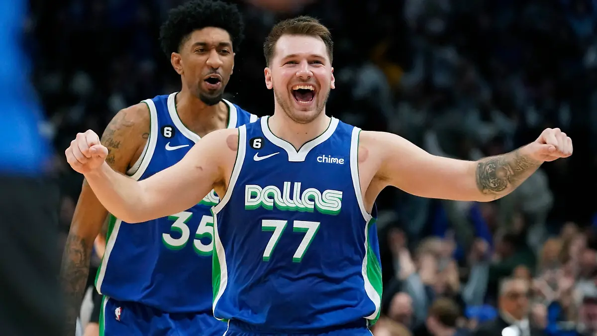 Dallas Mavericks guard Luka Doncic (77) celebrates scoring the game tying basket in front of teammate Christian Wood (35) during the fourth quarter of an NBA basketball game against the New York Knicks in Dallas, Tuesday, Dec. 27, 2022. The Mavericks won in overtime 126-121. (AP Photo/LM Otero)