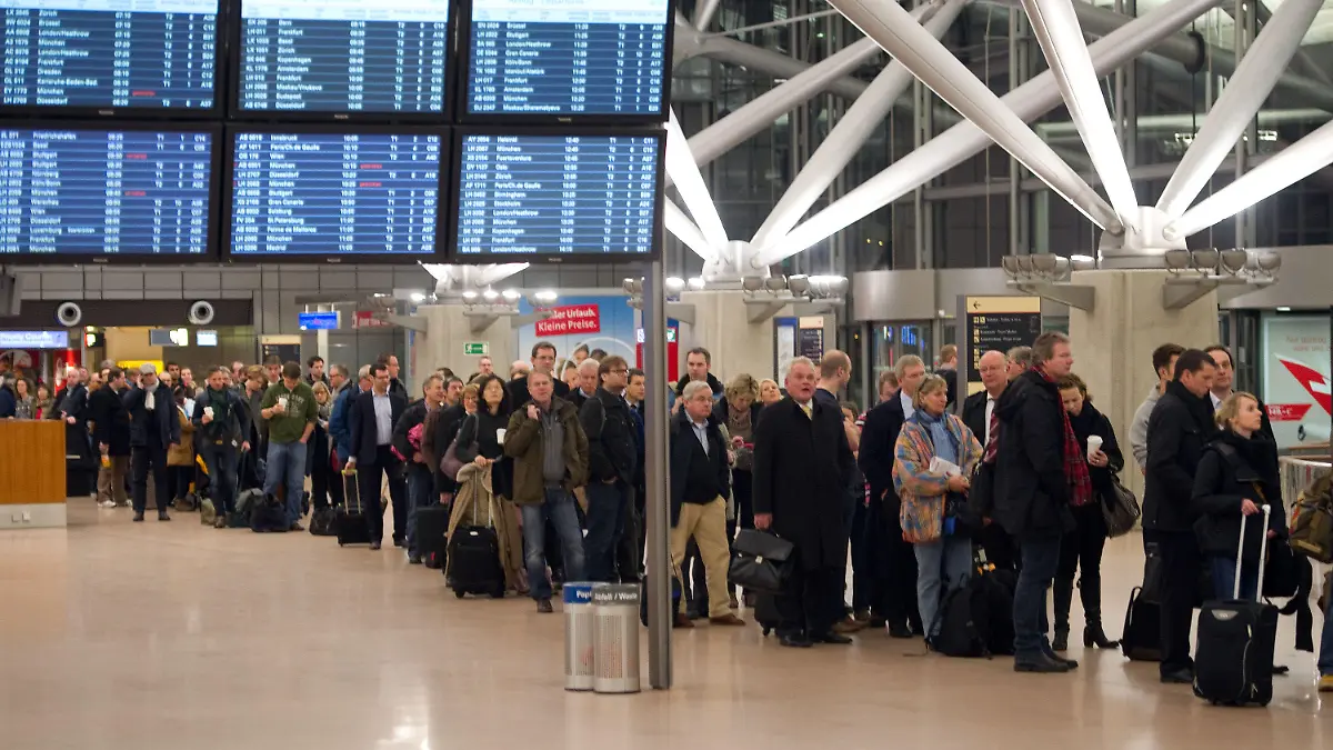 Flugpassagiere warten am 18.01.2013 in Hamburg im Flughafen in langen Schlangen auf die Abfertigung. Das Sicherheitspersonal des Hamburger Flughafens streikt für einen befristeten Zeitraum. Foto: Axel Heimken/dpa +++(c) dpa - Bildfunk+++