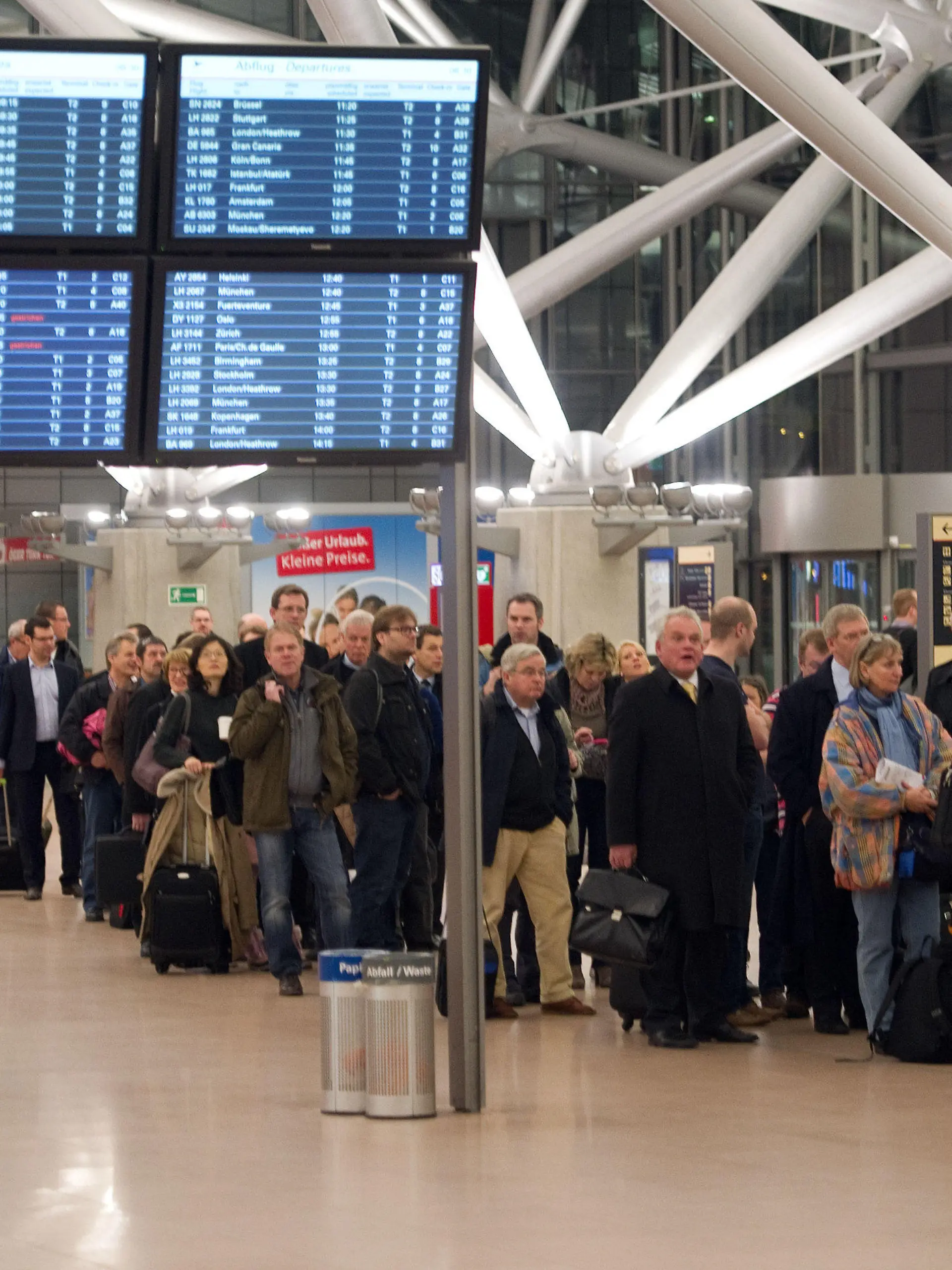 Flugpassagiere warten am 18.01.2013 in Hamburg im Flughafen in langen Schlangen auf die Abfertigung. Das Sicherheitspersonal des Hamburger Flughafens streikt für einen befristeten Zeitraum. Foto: Axel Heimken/dpa  +++(c) dpa - Bildfunk+++