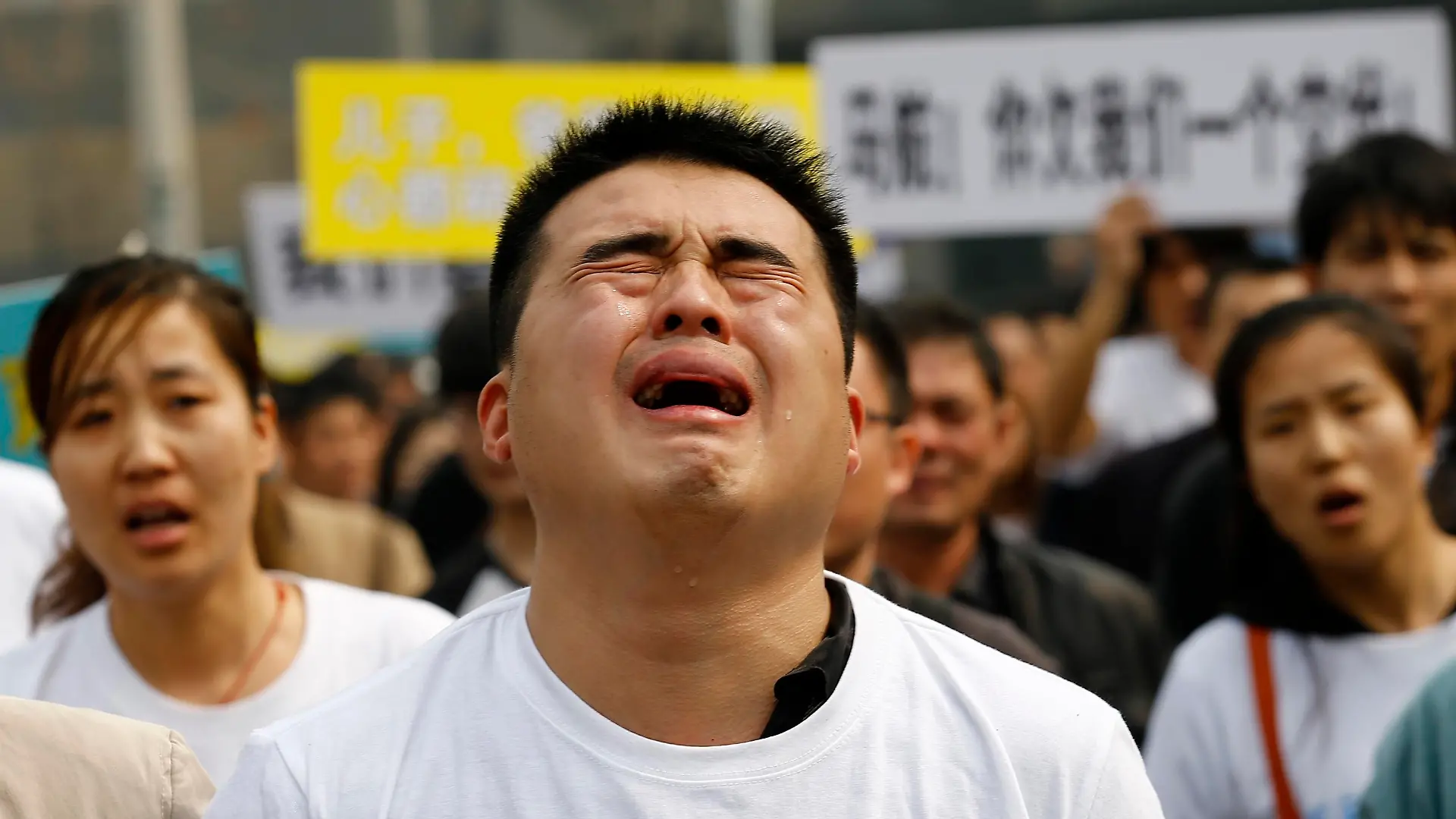 A family member of a passenger on board Malaysia Airlines MH370 cries as he shouts slogans during a protest in front of the Malaysian embassy in Beijing, March 25, 2014. Angry relatives of Chinese passengers aboard the missing Malaysia Airlines plane denounced the Kuala Lumpur government and its national carrier as 'executioners' on Tuesday and said they would march on the Malaysian Embassy. REUTERS/Kim Kyung-Hoon (CHINA - Tags: DISASTER CIVIL UNREST TRANSPORT POLITICS)