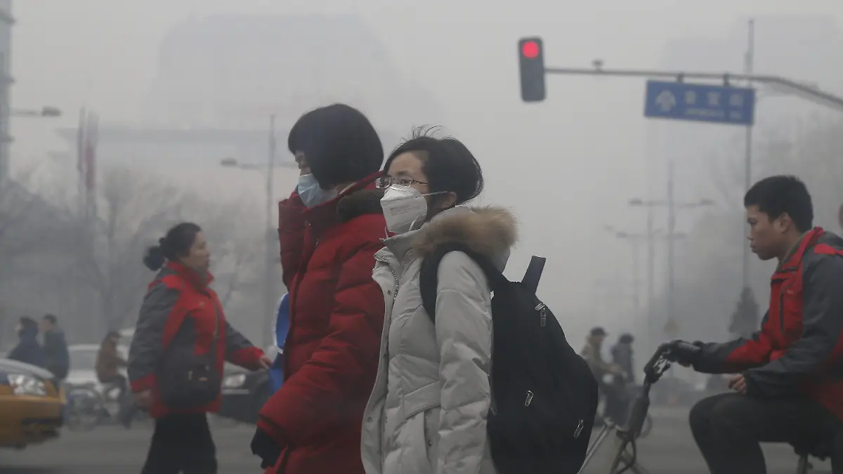 FILE - Pedestrians wear protective masks as they cross a road amidst smog in Beijing, China, 26 February 2014. Foto: Rolex Dela Pena/epa (zu dpa-Korr: "Fitness und Luftfilter: Unternehmen kämpfen gegen Smog in China" vom 01.03.2014) +++(c) dpa - Bildfunk+++