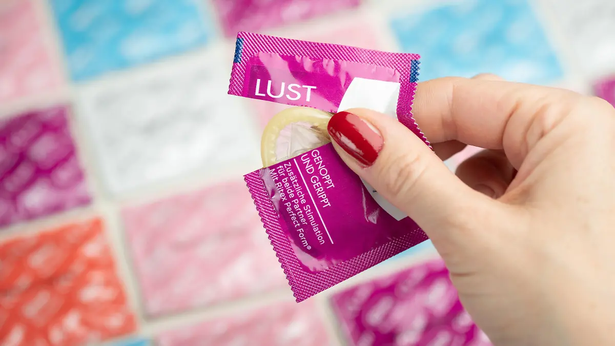 Ein Kondom ist aus einer Verpackung heraus zu sehen. Die strengen Kontakt-Auflagen in der Öffentlichkeit wegen der Corona-Krise lassen offensichtlich den Markt für heimisches Sexspielzeug und Kondome boomen. In Nordrhein-Westfalen sei vor allem der Verkauf von Solo-Sexartikeln wie Masturbationshilfsmitteln für Frauen und Männer extrem gestiegen.