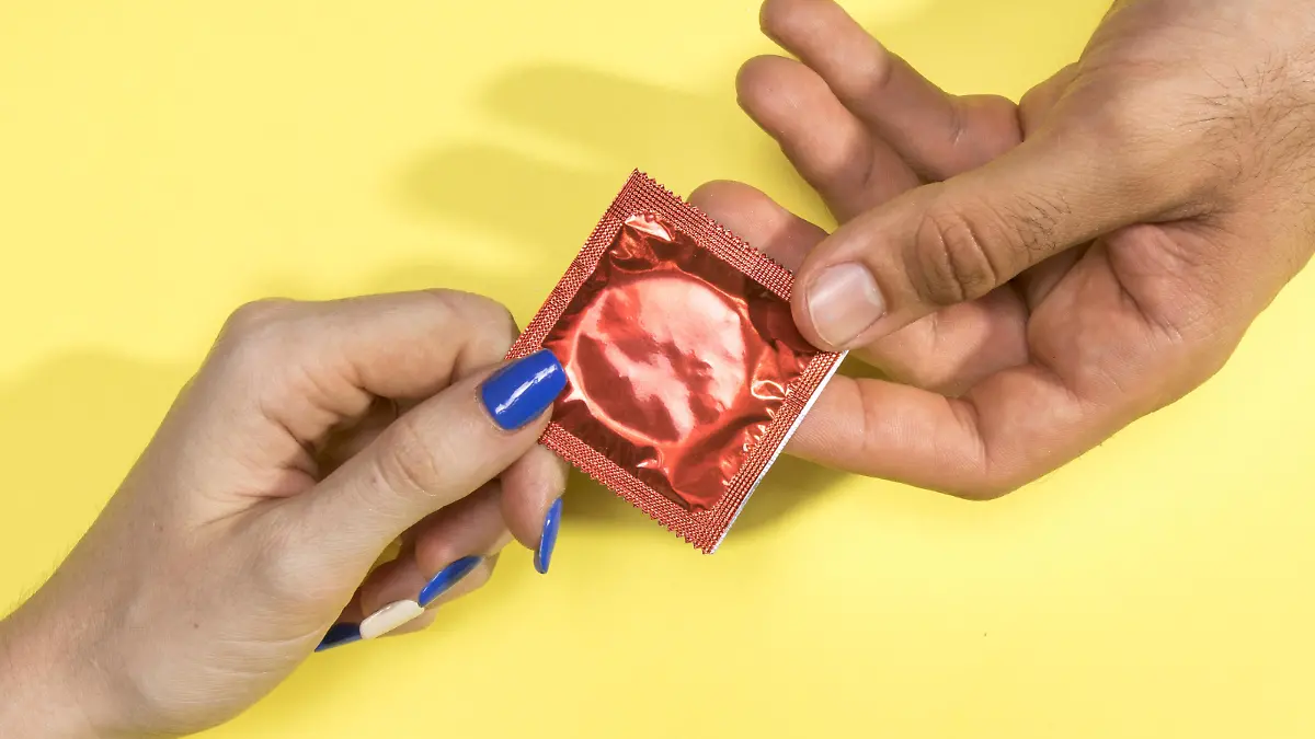 close up man woman holding condom