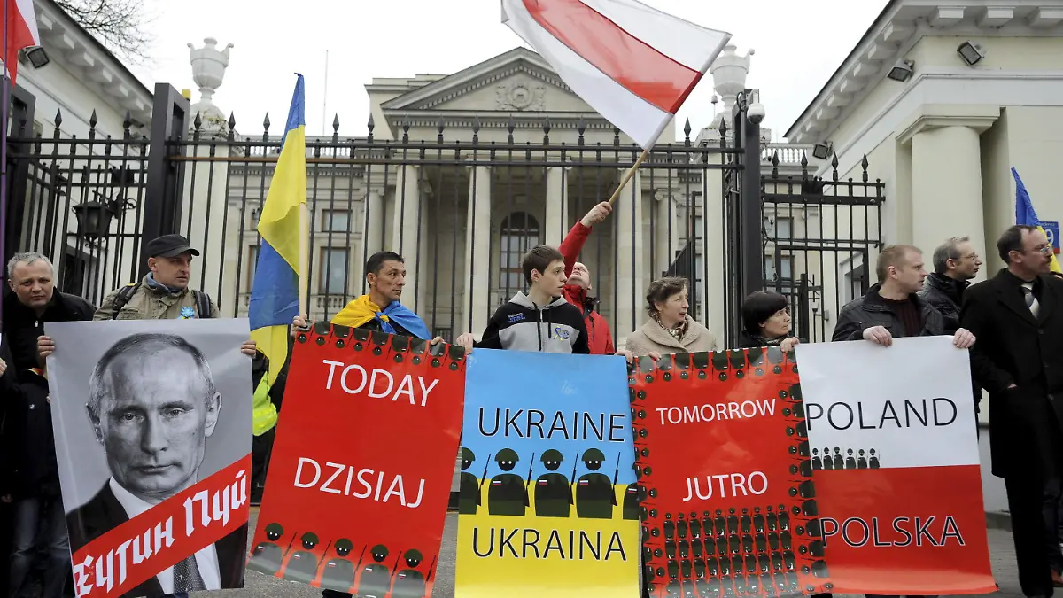 epa04137398 Ukrainians, Belarusians and Poles hold placards, banners and flags as they shout slogans during a protest against aggression, the situation in Crimea and war policies of Moscow as they rally in front of the Russian embassy in Warsaw, Poland, 23 March 2014. EPA/BARTLOMIEJ ZBOROWSKI POLAND OUT +++(c) dpa - Bildfunk+++