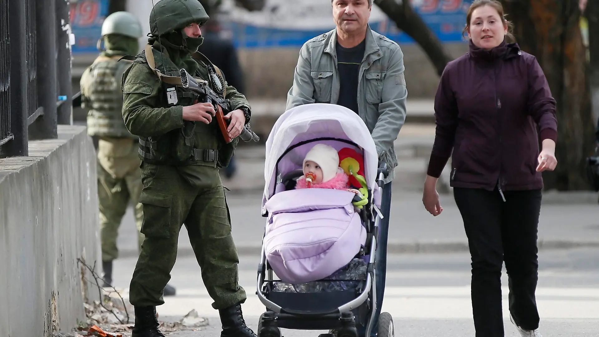 epa04132265 An armed man in military uniform patrols near the territory of a Ukrainian military unit in Simferopol, Ukraine, 19 March 2014. Pro-Russian activists on 19 March stormed the Ukrainian navy headquarters in Crimea, media reports said, a day after Russia signed an accession treaty with the leaders of the Black Sea peninsula. EPA/YURI KOCHETKOV +++(c) dpa - Bildfunk+++