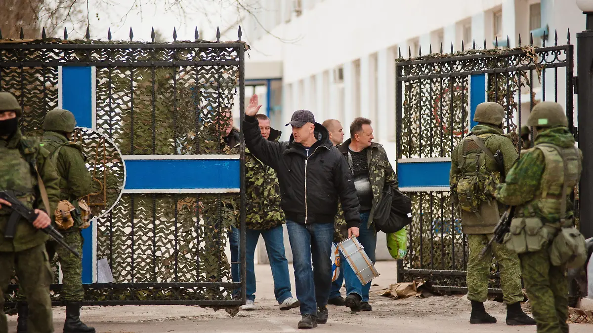 epa04132105 Ukrainian servicemen leave the territory of a Ukrainian military unit as armed men in military uniform control it in Sevastopol, Crimea, Ukraine, 19 March 2014. The servicemen in the Ukrainian naval headquarters in Sevastopol peacefully gave up their base after it was taken over by pro-Russian protesters, reports said. EPA/ANTON PEDKO +++(c) dpa - Bildfunk+++