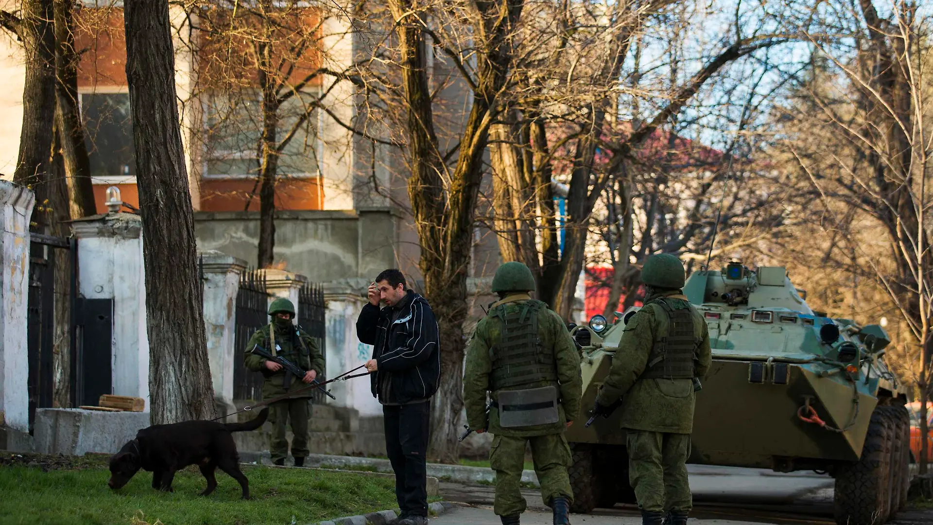 Armed men, believed to be Russian soldiers, stand guard outside a Ukrainian military base in Simferopol March 19, 2014. Defying Ukrainian protests and Western sanctions, Russian President Vladimir Putin signed a treaty in Moscow on Tuesday making Crimea part of Russia again, but said he did not plan to seize any other regions of Ukraine. REUTERS/Thomas Peter (UKRAINE - Tags: POLITICS MILITARY)