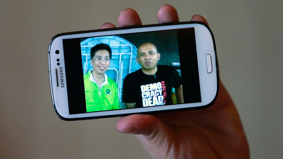 Peter Chong holds a smartphone displaying a picture of himself with missing Malaysia Airlines Flight MH370 captain Zaharie Ahmad Shah (R) during an interview with Reuters at a hotel in Sepang March 18, 2014. International media scrutiny and investigations by the Malaysian police have failed to turn up red flags on either the captain, 53-year-old grandfather Zaharie, or the co-pilot, 27-year old Fariq Abdul Hamid. Family and friends say there is nothing in their personalities or past to suggest they would have committed foul play. "I've never seen him lose his temper. It's difficult to believe any of the speculation made against him," said Chong, a friend of Zaharie, describing him as highly disciplined and conscientious. REUTERS/Samsul Said (MALAYSIA - Tags: DISASTER TRANSPORT TPX IMAGES OF THE DAY)