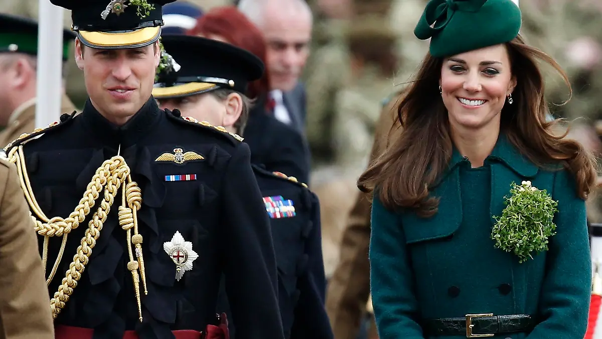 Britain's Catherine, Duchess of Cambridge and her husband Prince William wear sprigs of shamrock during a visit to the 1st Battalion Irish Guards for a St Patrick's Day Parade at Mons Barracks in Aldershot, southern England March 17, 2014. Prince William attended the Parade as Colonel of the Regiment, and the Duchess presented the traditional sprigs of shamrocks to the Officers and Guardsmen of the Regiment. REUTERS/Luke MacGregor (BRITAIN - Tags: ENTERTAINMENT MILITARY SOCIETY ROYALS)