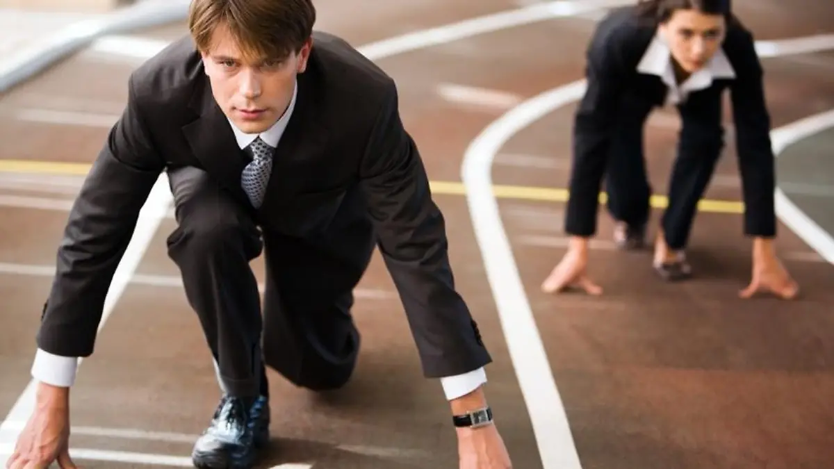 Businessman and businesswoman lined up getting ready for race in business 