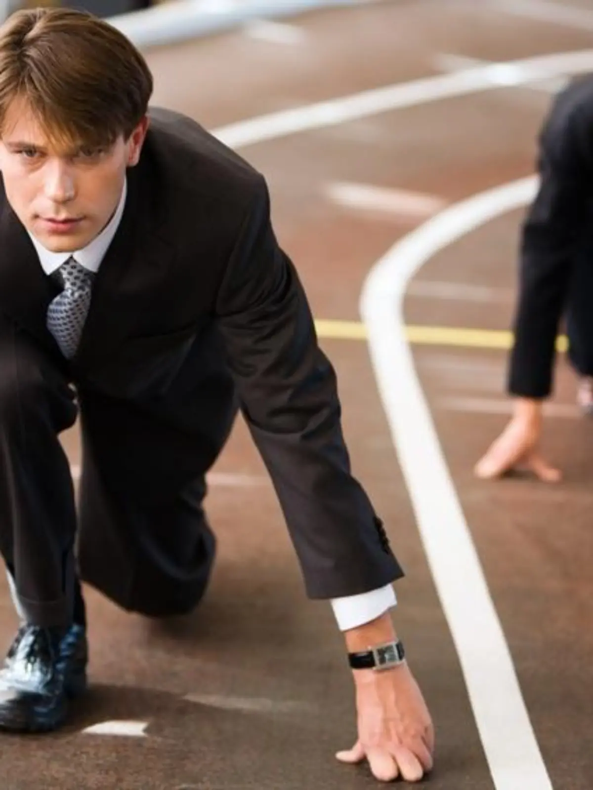 Businessman and businesswoman lined up getting ready for race in business 