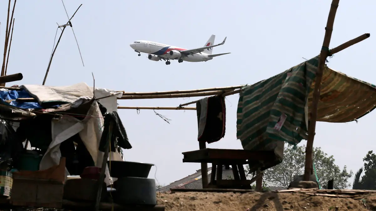 epa04129361 A Malaysia Airlines plane flies over shanties on the tenth day of the search of missing MH370A plane, in Manila, Philippines, 17 March 2014. According to report, Captain Zaharie Ahmad Shah, the pilot of the missing Malaysia Airlines Flight MH370 was trained at an aviaion school in the Philippines. The 52 year old pilot, born and raised in Penang in Malaysia, joined Malaysia Airlines in 1981 and was promoted to the rank of captain in the early 1990s. Malaysia Airlines flight MH370 with 239 people on board went missing early 08 March 2014 while on its way to Beijing. EPA/FRANCIS R. MALASIG DIS +++(c) dpa - Bildfunk+++