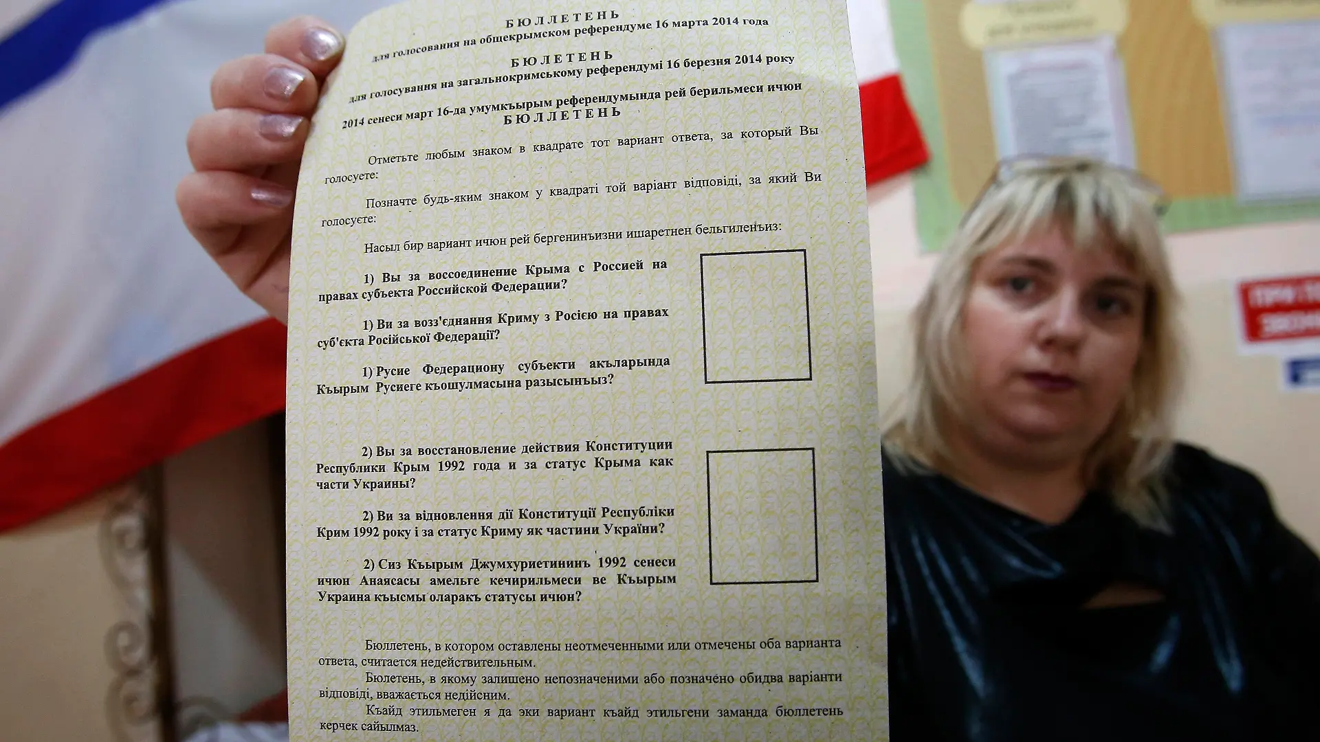 An election commission official shows a ballot paper for an upcoming referendum at the polling station in the Crimean town of Simferopol March 15, 2014. Pro-Russian leaders in Crimea made final preparations on Saturday for the referendum widely expected to transfer control of the Black Sea peninsula from Ukraine to Moscow, despite the threat of sanctions and condemnation from Western governments. REUTERS/David Mdzinarishvili (UKRAINE - Tags: POLITICS CIVIL UNREST ELECTIONS)